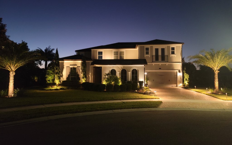 Accent lighting to include palm trees, driveway and second story.